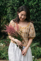 Woman holding a bouquet of flowers in a garden setting