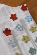Close-up of floral appliqués on deadstock cotton sleeveless top